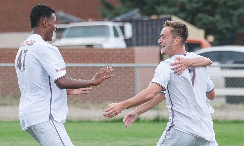 Shay Lonergan (right) celebrates with teammates including Mateo De Souza (left) after scoring a goal in a preseason scrimmage. Lonergan scored a penalty against Snow College as the Trappers went 1-1 against ranked opponents in Utah.
Tribune photo by Seth Romsa