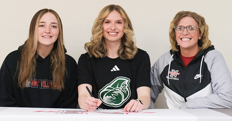 Ellianna Baumstarck (center) signed her letter of intent to continue her career at Bismarck State College in the fall. She was joined by teammates, including Landree Meeks (left), and coach Nicole Buck.