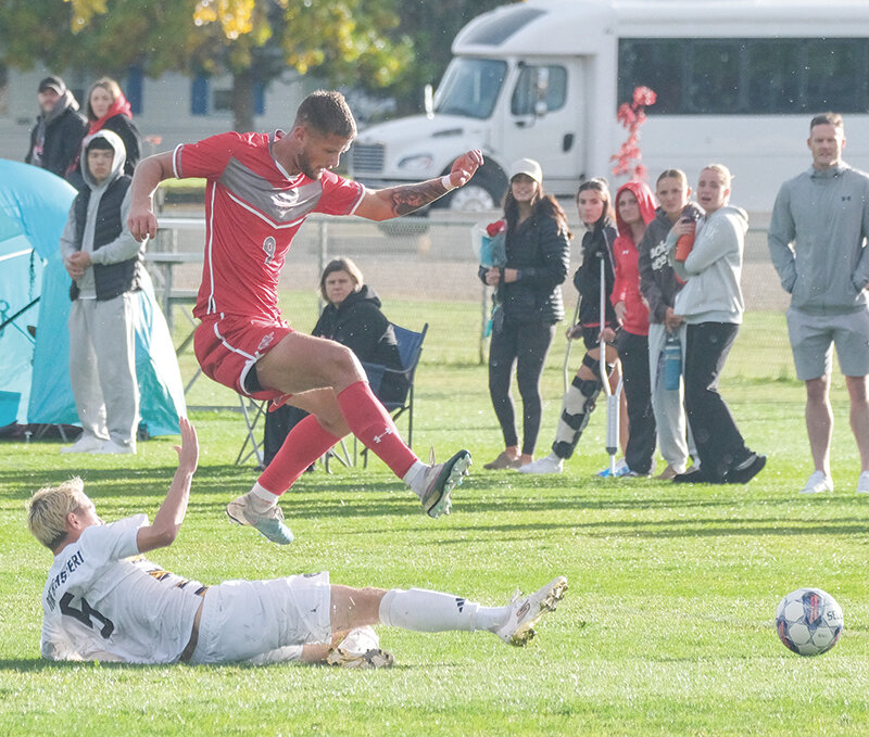 Cameron Low jumps over the sliding challenge of a Northeastern defender on Saturday. Low scored the first goal for the Trappers in a 3-1 win over Lamar on Friday.